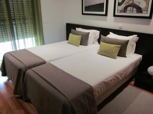 a bedroom with a large bed with pillows at Baia da Luz Resort in Luz