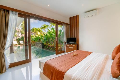 a bedroom with a bed and a view of a pool at Kahayana Seminyak Villa in Seminyak