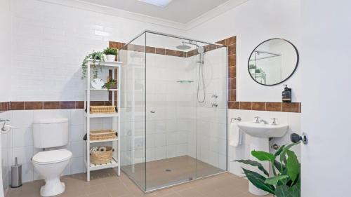 a bathroom with a shower with a toilet and a sink at 8 on Clarence in Moss Vale