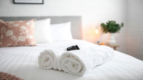 a pile of towels sitting on top of a bed at 8 on Clarence in Moss Vale