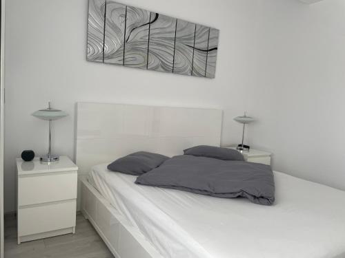 ein weißes Bett mit zwei Nachttischen und zwei Lampen in der Unterkunft Luxury Two Room Apartment Residence Militari M3 in Bukarest
