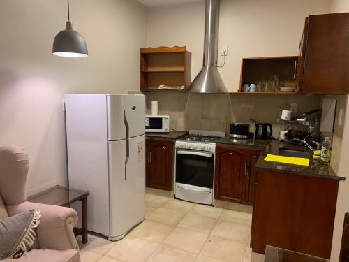 una cucina con frigorifero bianco e piano cottura di Los Naranjos Departamentos 2 a Concepción