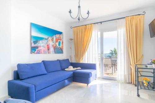 a blue couch in a living room with a window at Mi Capricho beach front sea view & pool - Happy Rentals in Mijas Costa