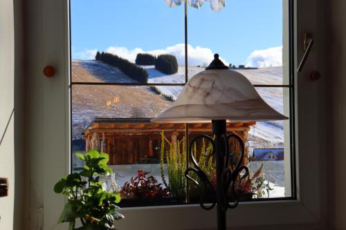a window with a lamp and a view of a snow covered yard at Schwarzes Ross Hotel & Restaurant Oberwiesenthal in Kurort Oberwiesenthal