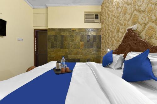 a hotel room with two beds with blue pillows at The Maurvi Inn in Jaipur