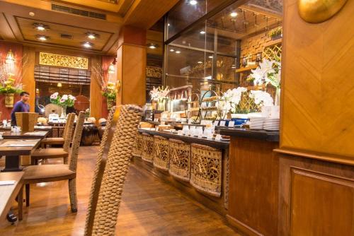 a restaurant with tables and chairs and a bar at Khum Phaya Resort & Spa Boutique Collection in Chiang Mai