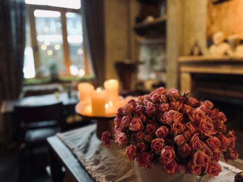 a bouquet of red roses in a vase on a table at Édouard Garden Café Guest Room in Durbuy