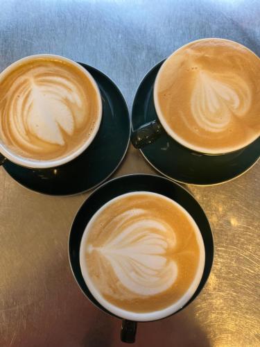three cups of coffee sitting on a table at Édouard Garden Café Guest Room in Durbuy