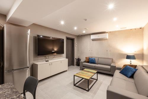 a living room with a couch and a flat screen tv at Charming,Comfortable and Centrally located Group Accomodation in Il-Gżira