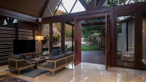 a screened in porch with a tv and chairs at Plataran Komodo Resort & Spa - CHSE Certified in Labuan Bajo