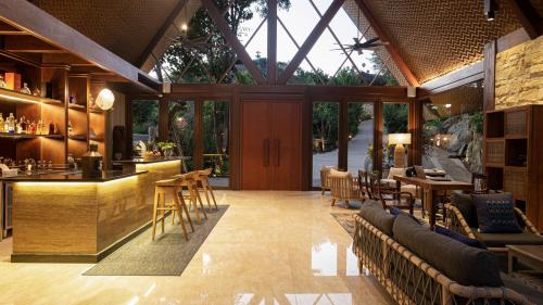 a restaurant with a bar and tables and chairs at Plataran Komodo Resort & Spa - CHSE Certified in Labuan Bajo