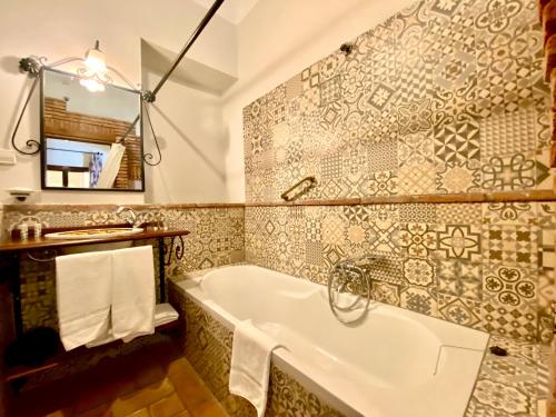 La salle de bains est pourvue d'une baignoire et d'un miroir. dans l'établissement El Rincón de las Descalzas, à Carmona