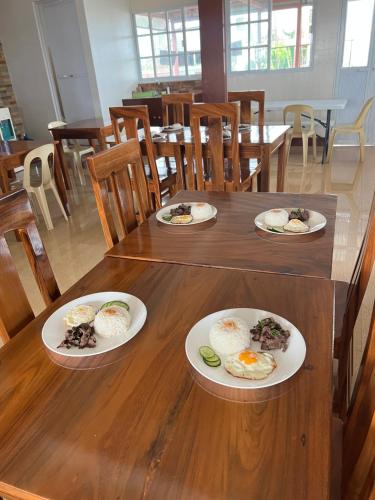 Casa de Milagrosa inn في كاليبو: طاولة خشبية عليها صحون طعام