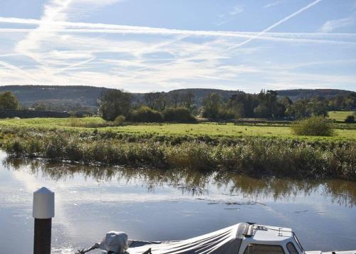 a boat is docked on a river with a field at Riverside Holiday Park in Amberley
