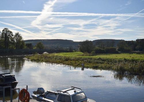 a boat is docked on a river in a field at Riverside Holiday Park in Amberley