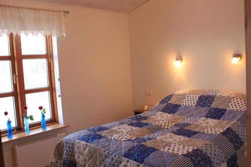 a bedroom with a blue and white bed and a window at Arabær Holiday Home in Arabaer