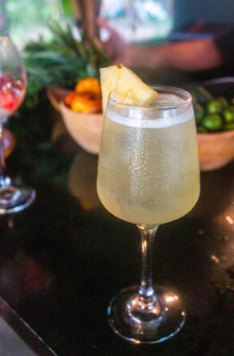 a glass of champagne on a table with a bowl of fruit at Eco Sanctuaries Nature Lodge Nacpan Beach, El Nido in El Nido