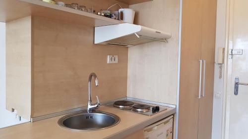 a small kitchen with a sink and a stove at Downtown Belgrade Hostel and Apartments in Belgrade