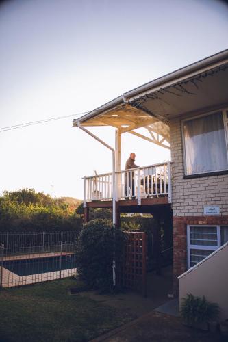 a man standing on the deck of a house at Rose and Ale Self Catering Units in Gonubie