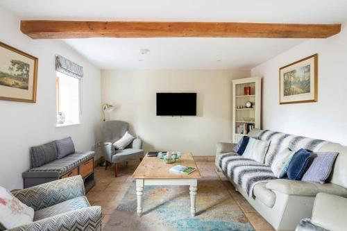a living room with a couch and a table at Coach House - detached cottage within 135 acres in Bromyard