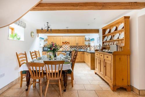 a dining room with a table and chairs in a kitchen at Coach House - detached cottage within 135 acres in Bromyard