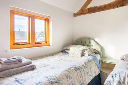 a small bedroom with a bed and a window at Coach House - detached cottage within 135 acres in Bromyard