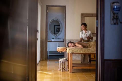 a woman standing next to a man laying on a table at Plataran Komodo Resort & Spa - CHSE Certified in Labuan Bajo