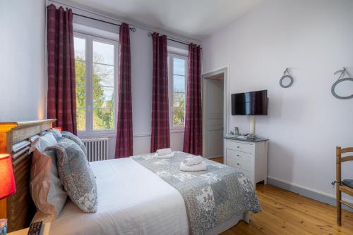 a bedroom with a bed and a window at H de Surgères in Surgères