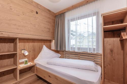 um pequeno quarto com uma cama e uma janela em Appartements Zirmhof em Vent