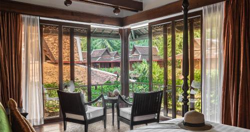 a room with a large window with a table and chairs at Angkor Village Hotel - Small Luxury Hotels of the World in Siem Reap