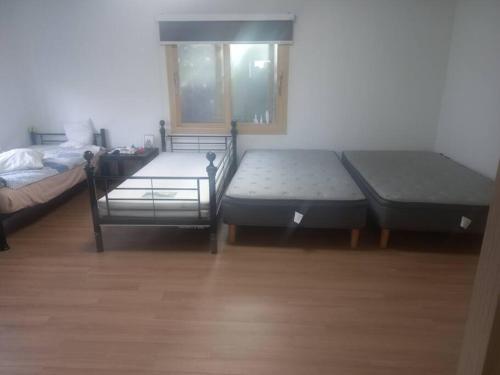 um quarto com duas camas e uma janela em Summer's House em Jeju