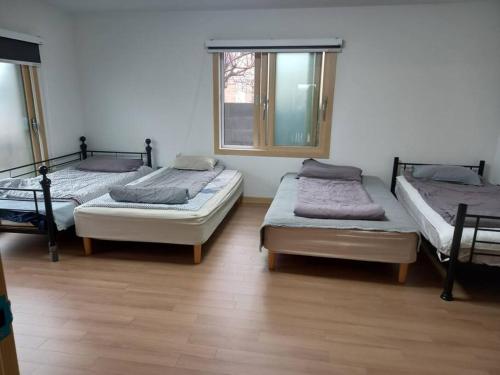 pokój z 3 łóżkami i oknem w obiekcie Summer's House w mieście Czedżu