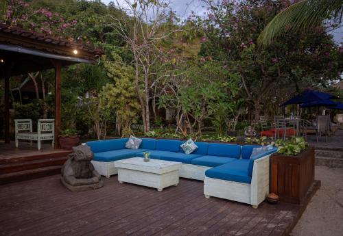 a blue couch sitting on top of a patio at Plataran Komodo Resort & Spa - CHSE Certified in Labuan Bajo