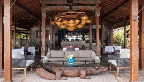 a dining room with a table and chairs and a large animal head at Plataran Komodo Resort & Spa - CHSE Certified in Labuan Bajo