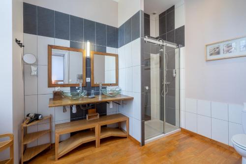 La salle de bains est pourvue d'une douche, d'un lavabo et d'un miroir. dans l'établissement H de Surgères, à Surgères