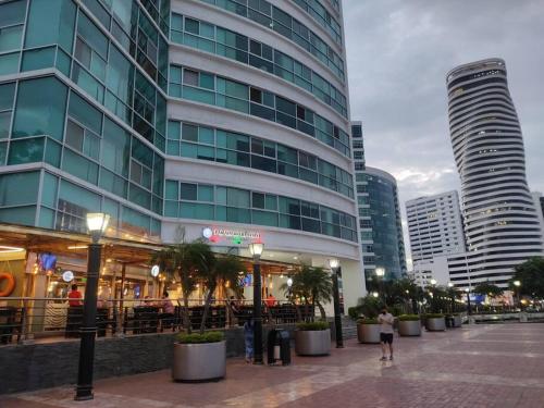 un edificio alto con gente parada fuera de él en Puerto santa Ana 2 habitaciónes, en Guayaquil