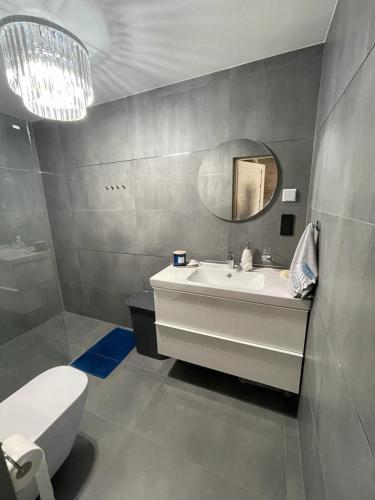 a bathroom with a sink and a mirror and a toilet at Jodłowy Zakątek NEW in Niechorze