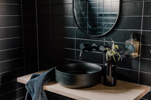 a black bathroom with a black sink and a mirror at Wander in the Scenic Rim in Wyaralong