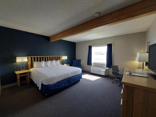 a bedroom with a bed and a desk and a television at Yogo Inn in Lewistown