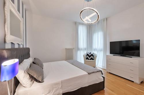 una camera bianca con un grande letto e una TV di Modern Apartment Casa Mia Easy to Venice a Treviso