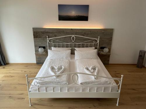 una camera da letto con un letto bianco con due cuori di Isartaler Hoamat Haus a Mittenwald