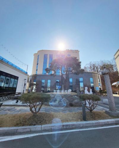 a building with a tree in front of it at Hotel Gongjicheon in Chuncheon