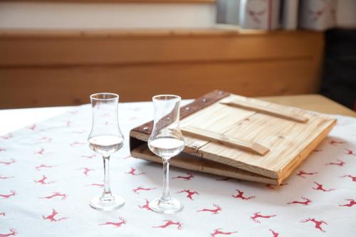 two wine glasses sitting on a table with a cutting board at Filzenhof in Kitzbühel