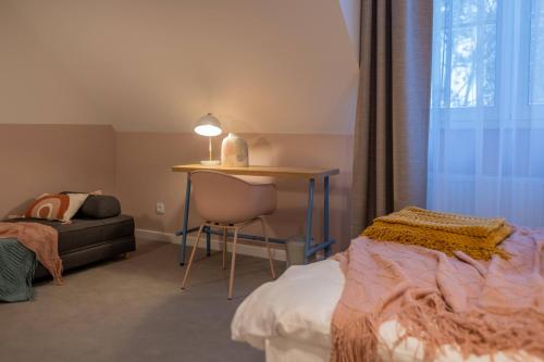 - une chambre avec un lit, un bureau et une chaise dans l'établissement Willa Zalesie, à Krynica-Zdrój