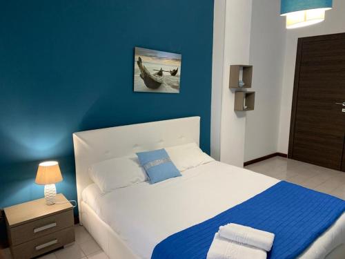ein Schlafzimmer mit einem Bett und einer blauen Wand in der Unterkunft URBANFLAT SALENTO in Lecce