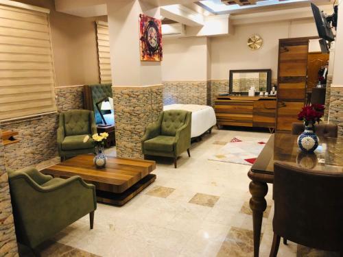 a hotel room with a bed and a table and chairs at Royal Eagle Hotel in An Najaf