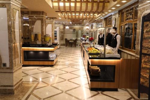 a buffet line in a hotel with people preparing food at Royal Eagle Hotel in An Najaf