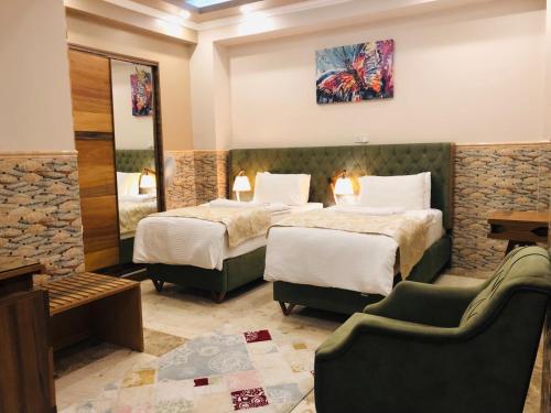 a hotel room with two beds and a couch at Royal Eagle Hotel in An Najaf