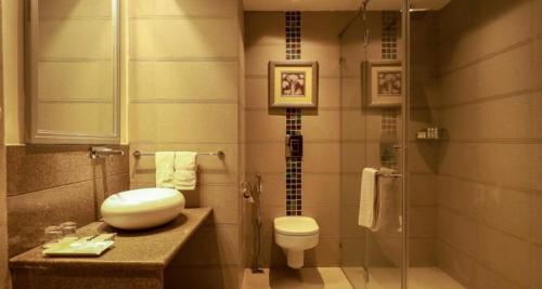 a bathroom with a toilet and a sink and a shower at The Greenwood, Tezpur in Tezpur