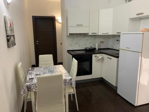eine kleine Küche mit einem Tisch und weißen Geräten in der Unterkunft URBANFLAT SALENTO in Lecce